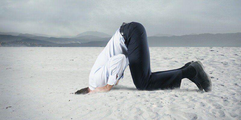 Person doing a headstand on a snowy beach by the water